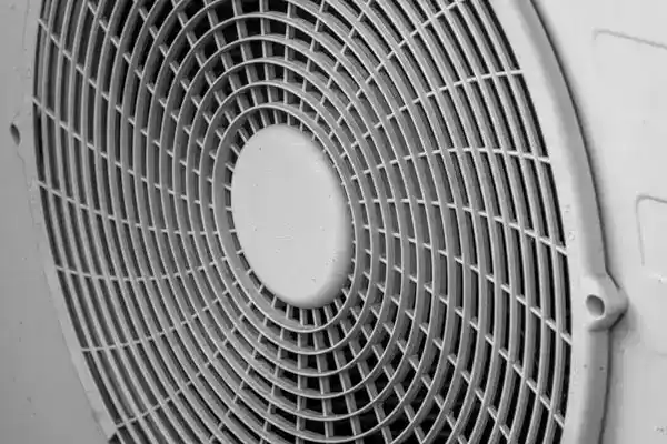 Close-up view of the front grill and blades of an electric fan, showing circular metal bars and central hub—perfect for homes in Boston, MA looking to boost airflow after a heat pump repair.