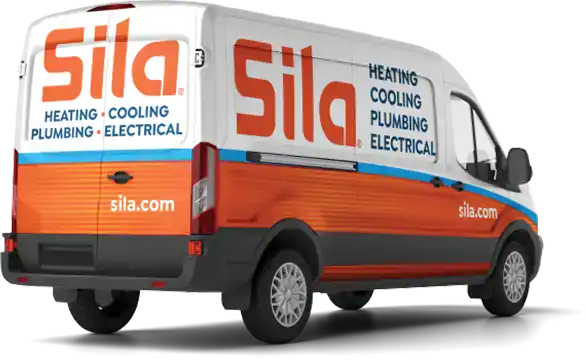A white and orange Sila service van with text advertising heating, cooling, plumbing, and electrical services, and the website sila.com.